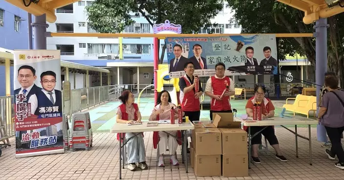 馮沛賢聯同李廣宇向居民派發小型滅火筒 提升家居防火意識